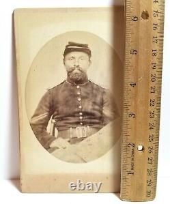 Union Army soldier holding Civil War Confederate coat, New York, cabinet photo